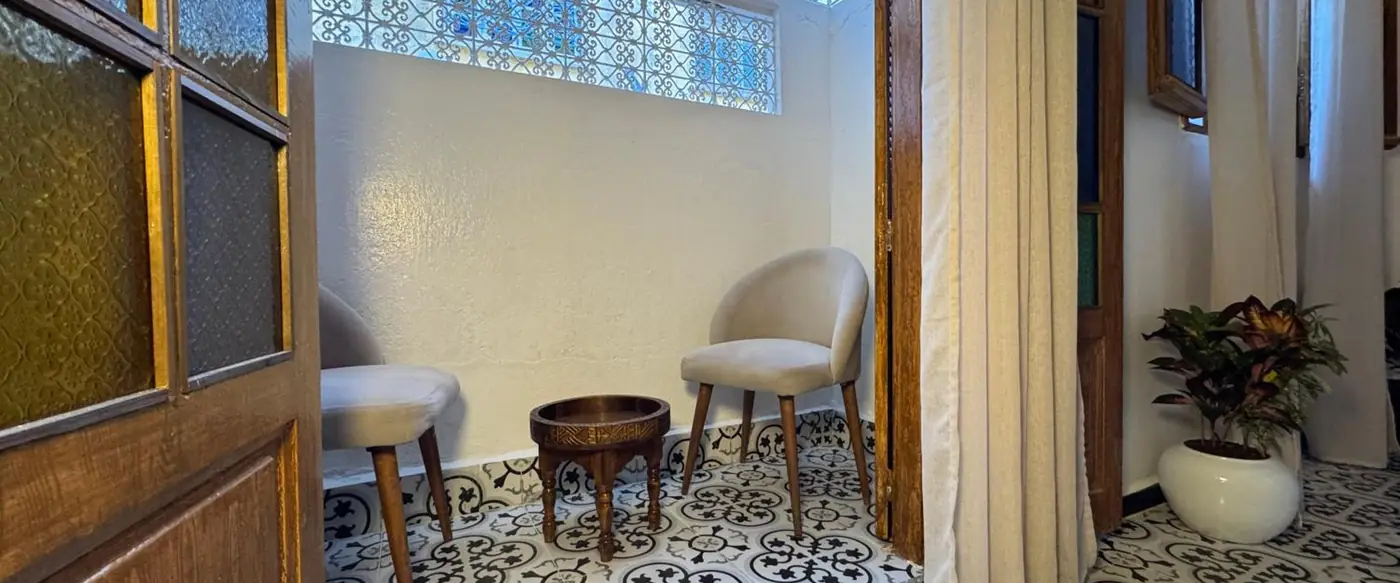 Deux fauteuils sous la grande fenêtre du couloir