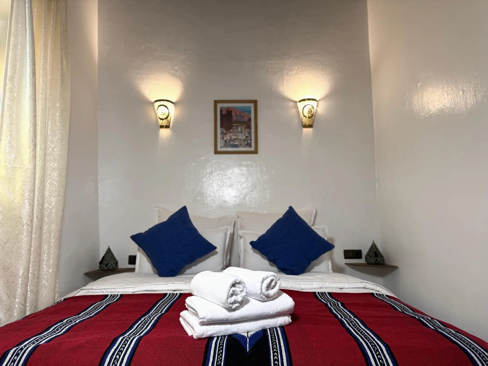 La chambre double, son plaid rouge et ses coussins bleus
