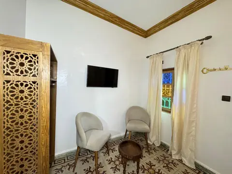 Le placard sculpté et les fauteuils de la chambre double climatisée