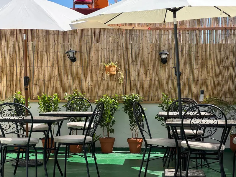 La terrasse, ses tables et la palissade de bambou